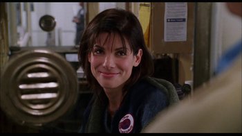 Movie still from “While You Were Sleeping” (1995), directed by Jon Turteltaub – A person sitting at a table; Close Up shot, Over the shoulder angle