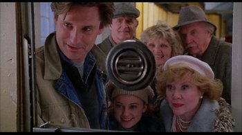 Movie still from “While You Were Sleeping” (1995), directed by Jon Turteltaub – A group of people standing next to each other in front of a mirror; Medium shot, Low angle