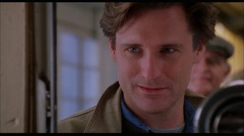 Movie still from “While You Were Sleeping” (1995), directed by Jon Turteltaub – A man's face in a tan jacket; Close Up shot, Over the shoulder angle