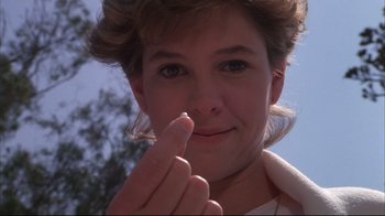 Movie still from “White Dog” (1982), directed by Samuel Fuller – A woman holding a piece of paper in one hand and a finger in the other; Close Up shot, Low angle