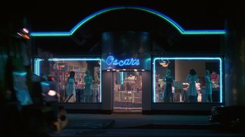 Movie still from “White Dog” (1982), directed by Samuel Fuller – A store front at night lit up with neon lights; Extreme Wide shot, Low angle
