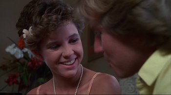 Movie still from “White Dog” (1982), directed by Samuel Fuller – A young woman smiling at a man in a suit; Close Up shot, Over the shoulder angle