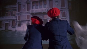 Movie still from “White Dog” (1982), directed by Samuel Fuller – Two people in red hats are looking at a projection screen; Medium shot, Low angle