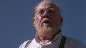 Movie still from “White Dog” (1982), directed by Samuel Fuller – An old man with a beard wearing glasses and suspenders; Close Up shot, Low angle