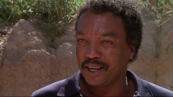 Movie still from “White Dog” (1982), directed by Samuel Fuller – A person wearing a purple shirt; Close Up shot, Low angle