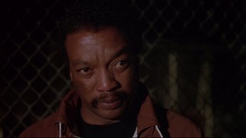 Movie still from “White Dog” (1982), directed by Samuel Fuller – A person wearing a brown jacket; Close Up shot, Low angle