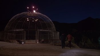 Movie still from “White Dog” (1982), directed by Samuel Fuller – Two people standing in front of a building at night; Extreme Wide shot, Low angle