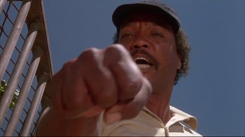 Movie still from “White Dog” (1982), directed by Samuel Fuller – A man in a baseball cap points at the camera; Close Up shot, Low angle