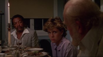 Movie still from “White Dog” (1982), directed by Samuel Fuller – A woman sitting at a table with a plate of food in front of her; Close Up shot, Over the shoulder angle