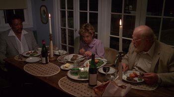 Movie still from “White Dog” (1982), directed by Samuel Fuller – A group of people sitting at a dinner table; Medium shot, High angle