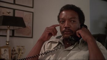 Movie still from “White Dog” (1982), directed by Samuel Fuller – A man holding a phone up to his ear; Close Up shot, Low angle