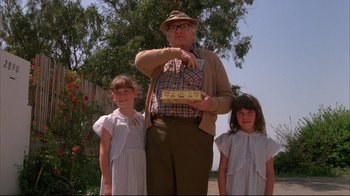 Movie still from “White Dog” (1982), directed by Samuel Fuller – An old man and two little girls standing next to each other; Medium shot, Low angle
