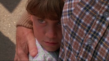 Movie still from “White Dog” (1982), directed by Samuel Fuller – A person holding a child's arm; Close Up shot, Over the shoulder angle