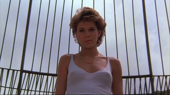 Movie still from “White Dog” (1982), directed by Samuel Fuller – A young woman wearing a tank top and a chain necklace; Close Up shot, Low angle