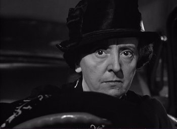 Movie still from “White Heat” (1949), directed by Raoul Walsh – An older woman wearing a hat and looking at the camera; Close Up shot, Low angle