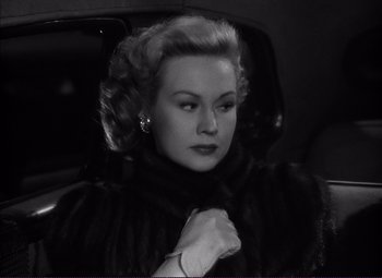 Movie still from “White Heat” (1949), directed by Raoul Walsh – An old photo of a woman sitting in the back of a car; Close Up shot, Over the shoulder angle