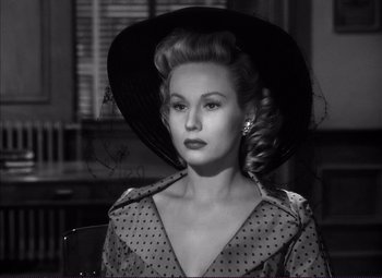 Movie still from “White Heat” (1949), directed by Raoul Walsh – A black and white photo of a woman wearing a hat; Close Up shot, Low angle