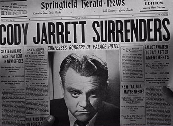 Movie still from “White Heat” (1949), directed by Raoul Walsh – A black and white photo of a newspaper with a picture of a man; Close Up shot, Overhead angle