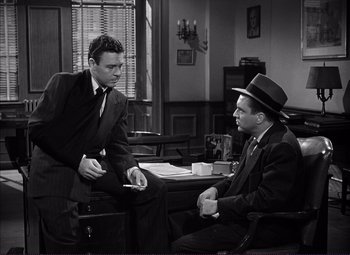 Movie still from “White Heat” (1949), directed by Raoul Walsh – Two men are sitting at a table in a room; Medium shot, High angle