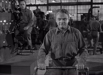 Movie still from “White Heat” (1949), directed by Raoul Walsh – A man holding a cane in a room with other people; Medium shot, Low angle