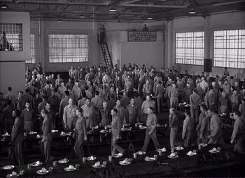 Movie still from “White Heat” (1949), directed by Raoul Walsh – A large group of men standing in a room; Extreme Wide shot, High angle