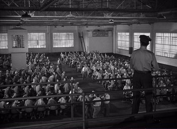 Movie still from “White Heat” (1949), directed by Raoul Walsh – A large group of people sitting in a large room; Extreme Wide shot, High angle