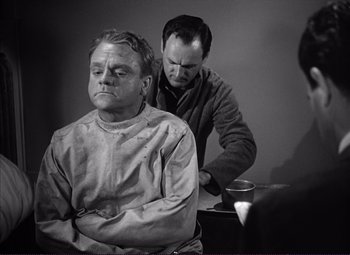 Movie still from “White Heat” (1949), directed by Raoul Walsh – A man sitting in front of another man in front of a table; Medium shot, Over the shoulder angle