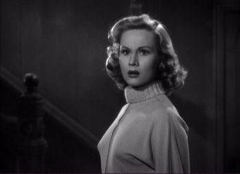 Movie still from “White Heat” (1949), directed by Raoul Walsh – A black - and - white photo of a woman in a sweater; Close Up shot, Over the shoulder angle