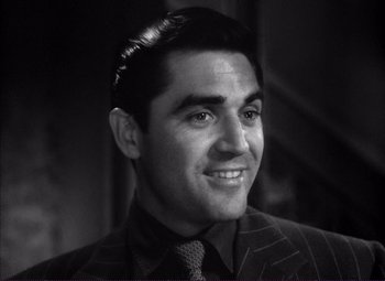 Movie still from “White Heat” (1949), directed by Raoul Walsh – Black and white photograph of a man smiling; Close Up shot, High angle