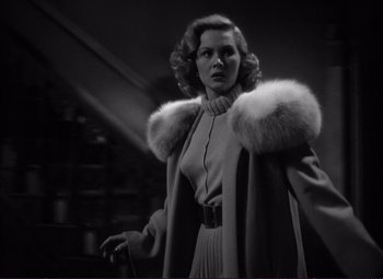 Movie still from “White Heat” (1949), directed by Raoul Walsh – A black and white photo of a woman wearing a fur coat; Medium shot, Low angle