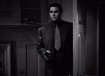 Movie still from “White Heat” (1949), directed by Raoul Walsh – A black and white photo of a man in a suit and tie; Medium shot, Low angle