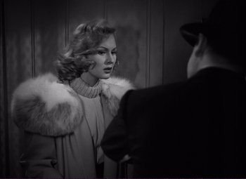 Movie still from “White Heat” (1949), directed by Raoul Walsh – A woman wearing a fur coat looking in the mirror; Medium shot, Over the shoulder angle