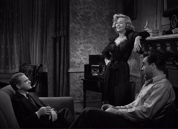 Movie still from “White Heat” (1949), directed by Raoul Walsh – A man and two women sitting in a living room; Medium shot, High angle