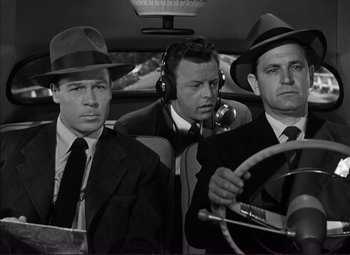 Movie still from “White Heat” (1949), directed by Raoul Walsh – A group of men sitting in the back of a car; Medium shot, Low angle