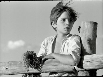 Movie still from “White Mane” (1953), directed by Albert Lamorisse – A young boy holding a bouquet of flowers; Close Up shot, Low angle