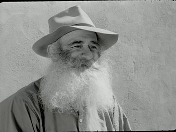 Movie still from “White Mane” (1953), directed by Albert Lamorisse – An old man with a long white beard wearing a hat; Close Up shot, Low angle