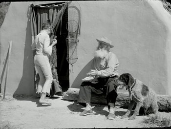 Movie still from “White Mane” (1953), directed by Albert Lamorisse – An old photo of a man and a woman with a dog; Wide shot, Low angle