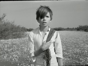 Movie still from “White Mane” (1953), directed by Albert Lamorisse – A young person standing in the middle of an open field; Medium shot, Low angle