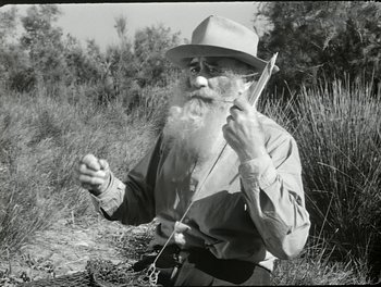 Movie still from “White Mane” (1953), directed by Albert Lamorisse – An old man with a long white beard holding a stick in his hands; Close Up shot, Low angle