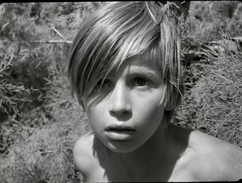 Movie still from “White Mane” (1953), directed by Albert Lamorisse – A young boy with a very short haircut; Close Up shot, Low angle