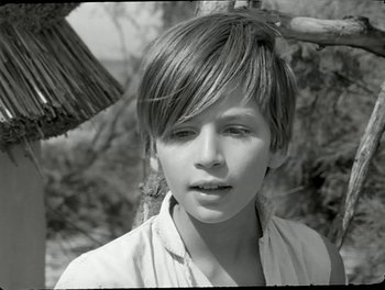 Movie still from “White Mane” (1953), directed by Albert Lamorisse – A young boy is looking into the distance; Close Up shot, Over the shoulder angle
