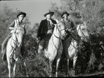 Movie still from “White Mane” (1953), directed by Albert Lamorisse – A group of people riding on the backs of horses; Wide shot, Low angle