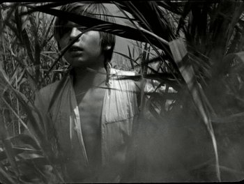 Movie still from “White Mane” (1953), directed by Albert Lamorisse – A black and white photo of a man in a field; Medium shot, Low angle
