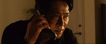 Movie still from “Why Don't You Play in Hell?” (2013), directed by Sion Sono – A person talking on a cell phone; Close Up shot, Low angle