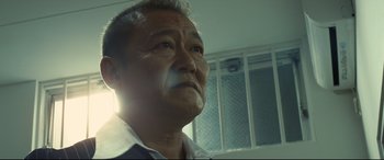 Movie still from “Why Don't You Play in Hell?” (2013), directed by Sion Sono – An older man looking up into the sky; Close Up shot, Low angle