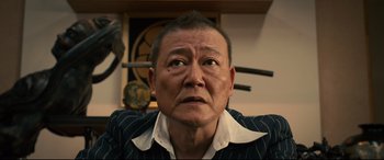 Movie still from “Why Don't You Play in Hell?” (2013), directed by Sion Sono – An older asian man looking up into the air; Close Up shot, Low angle