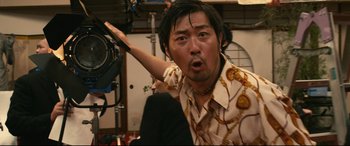 Movie still from “Why Don't You Play in Hell?” (2013), directed by Sion Sono – A man with a surprised look on his face; Close Up shot, Low angle