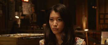 Movie still from “Why Don't You Play in Hell?” (2013), directed by Sion Sono – A person with long black hair; Close Up shot, Low angle