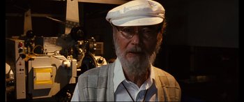 Movie still from “Why Don't You Play in Hell?” (2013), directed by Sion Sono – An older man with a beard wearing a white hat; Close Up shot, Low angle