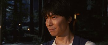 Movie still from “Why Don't You Play in Hell?” (2013), directed by Sion Sono – A person wearing a white t - shirt; Close Up shot, Low angle